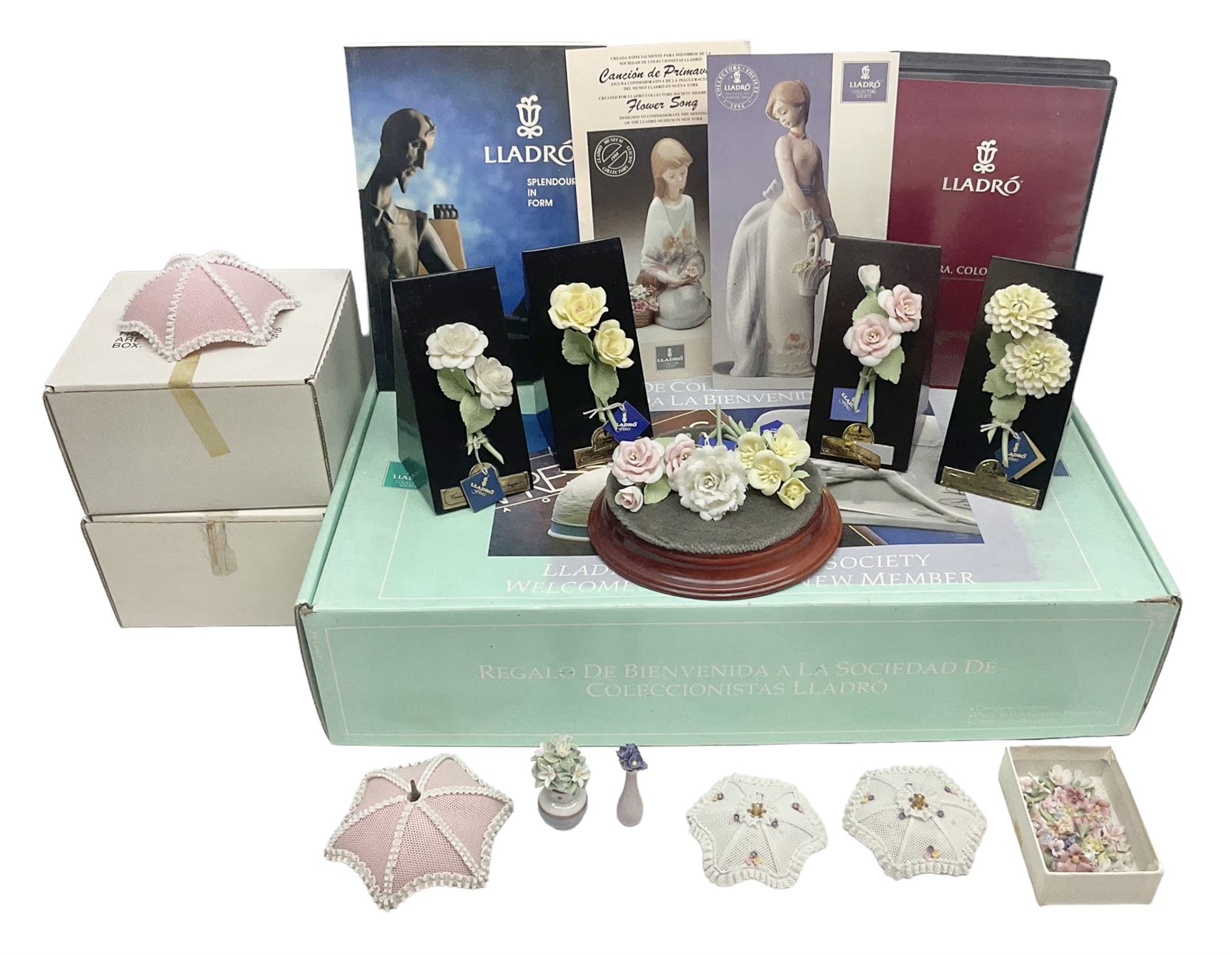 Seven Lladro flowers, comprising Japanese Camelia on base no 5181, Yellow Begonia on base no 5186, Miniature Begonia on base no 5188, Chrysanthemum on base no 5189, California Poppy no 5190.B, Miniature Begonia 5188.B and White Carnation no 5184.B, together with Lladro Spanish Joining pack with 17616 Winter Bell, Additional Lladro parasols and flowers etc 