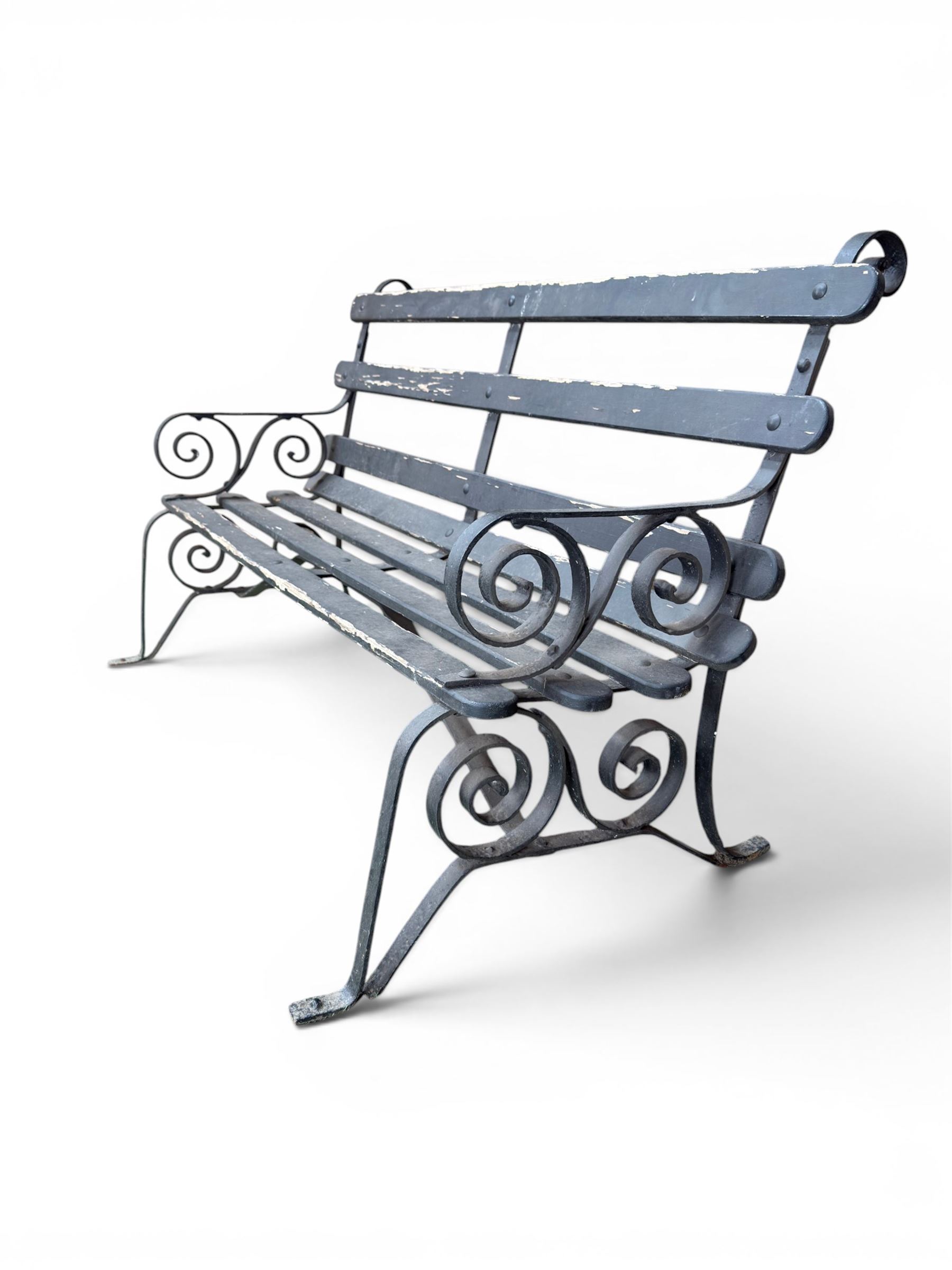 Coalbrookdale - rare pair of wrought iron and slatted wood garden benches, the twin wrought iron strapwork bench-ends formed of four scrolls over splayed feet, number 77 in the Coalbrookdale Castings Catalogue (see illustration)