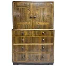 Early 20th century Art Deco walnut cocktail tallboy chest, fitted with double cupboard enclosing two shelves over two short and three long drawers, each with shell shaped handes