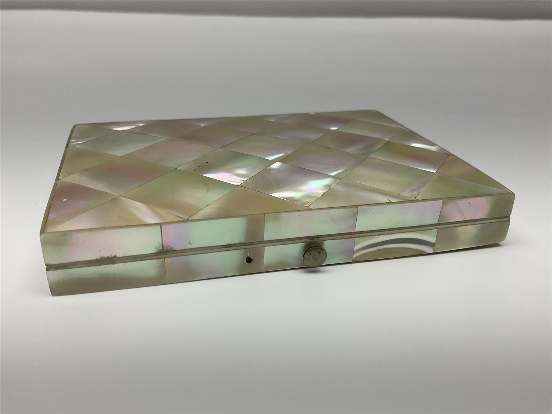 Victorian mother of pearl tea caddy, of rectangular bow-fronted form, the body with floral, bird and geometric engraved mother of pearl panels, white metal shield plaque to the cover inscribed with the initials G.J.A and similar escutcheon, the two division interior with ivory edging and two panelled mother of pearl lids, on four vegetable ivory bun feet L20cm, together with a similar style mother of pearl card case (2) This item has been registered for sale under Section 10 of the APHA Ivory Act