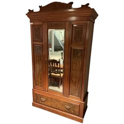 Late Victorian walnut wardrobe, carved arched pediment, fitted with single bevelled mirror door, flanked by carved and figured panels, enclosing hanging rail and hooks, single drawer fitted to base