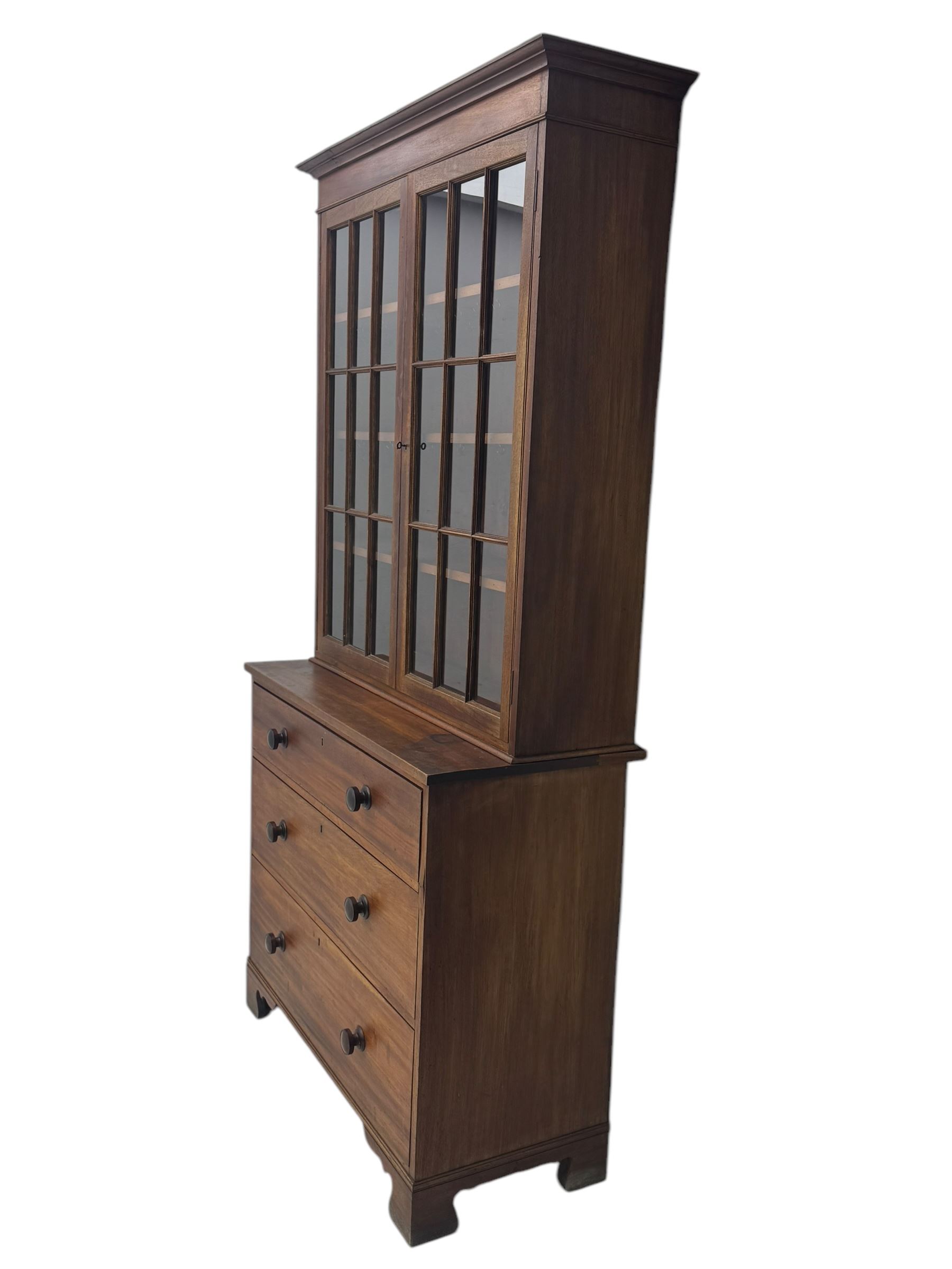 Late 19th century mahogany bookcase on chest, projecting moulded cornice over twin astragal glazed doors enclosing three shelves, base fitted with three graduated drawers, raised on shaped bracket supports