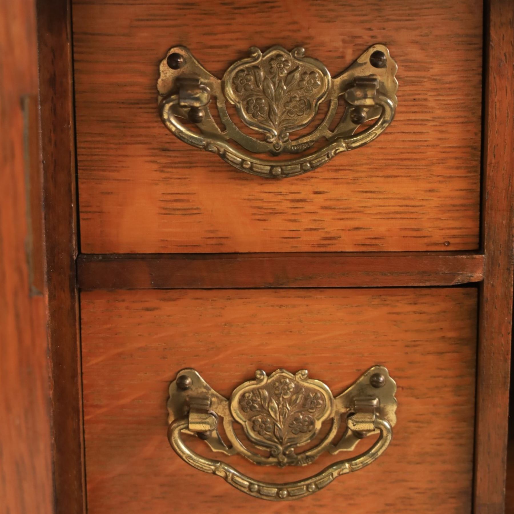 19th century oak table top smokers cabinet, with carved foliate pediment, the two beveled edge glass doors opening to reveal a fitted interior, with four drawers and fitted brass of pipe holders to each door, H46cm