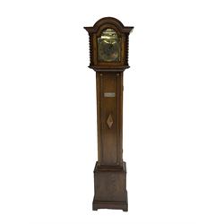 English - Mid 20th century oak three train 8-day grandmother clock, with a break-arch pediment and conforming hood door flanked by barley twist columns, full length trunk door on a rectangular plinth with a shaped base, brass dial with spandrels and chapter ring and matted dial centre, quarter chiming movement on five gong rods. With pendulum and key.