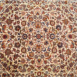 Central Persian Najafabad hand-knotted carpet, ivory field with an all-over scrolling floral design of palmettes, rosettes, and leafy vine work, enclosed by a wide floral main border flanked by multiple guard borders in madder red, indigo blue, green, and pale ochre, with cotton fringe ends 