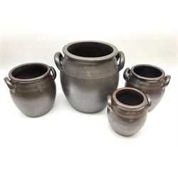 Set of four Swedish Hoganas cooking pots with twin handles, each pot imprinted with makers mark, pots sized two litres H16.5, three litres H19.5, four litres H21cm, 10 litres 29cm. 