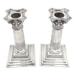 Pair of late Victorian silver Corinthian column candlesticks, each with removable beaded nozzle upon foliate capital, fluted column and filled stepped base, hallmarked James Charles Jay, London 1895, H16cm