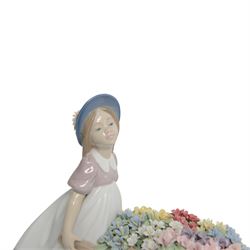 Lladro, Love's tender tokens girl, with floral filled wheelbarrow, model 6521, H23cm