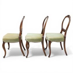 Victorian mahogany dining suite, oval tilt top dining table raised on a quatriform base with paw feet, together with a set of six balloon back dining chairs with green upholstery with cabriole legs 