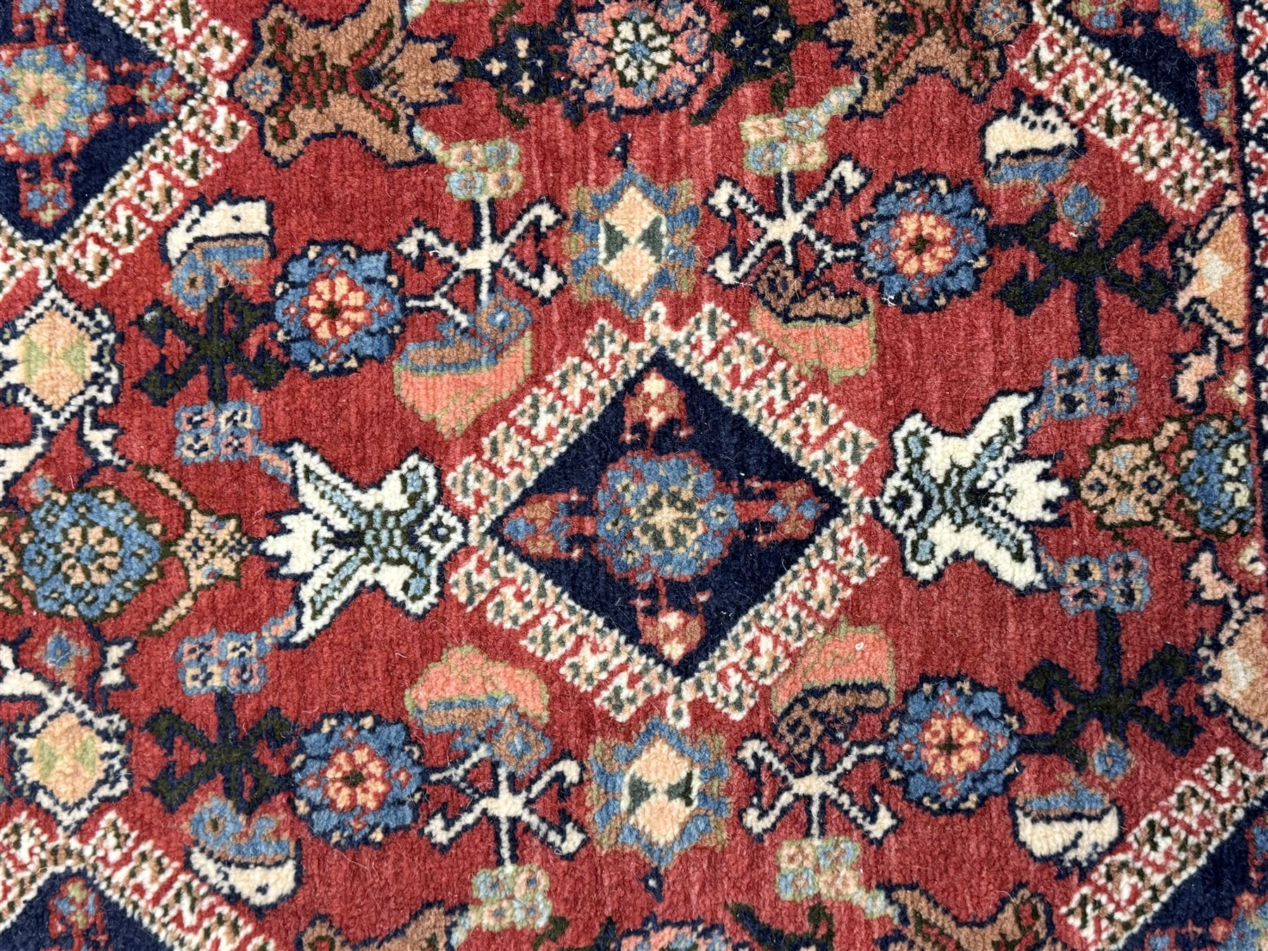 Pair of rugs one Persian hamadan rug central stepped medallion enclosing geometric motifs in ivory and brown, framed by a cream border with scrolling palmettes and fringed ends (H 156cm W 105cm), one Pakistani Bokhara rug rust red ground with repeated Tekke gul motifs within rosette and lozenged borders, fringed ends (H 98cm, W 65cm)