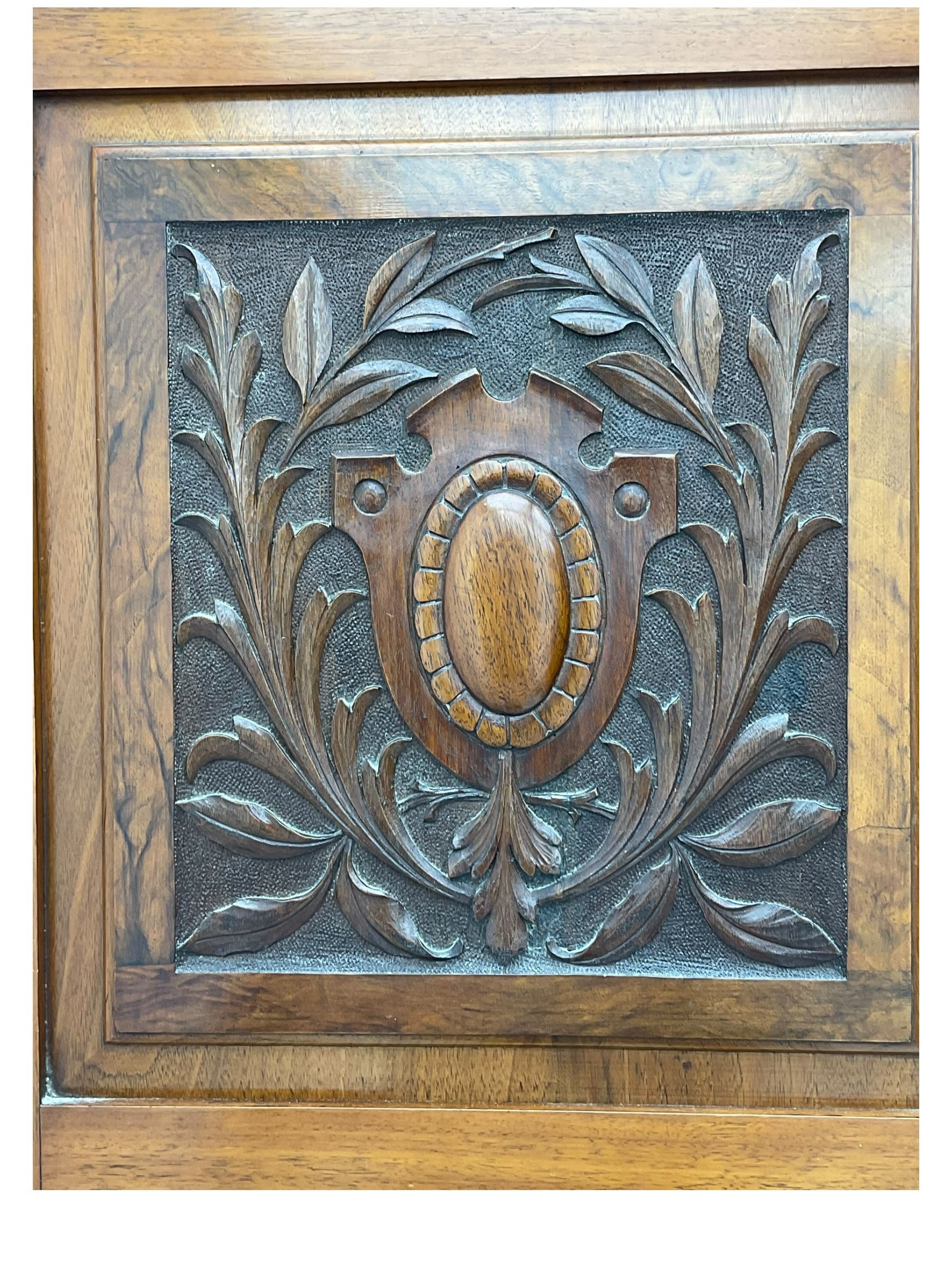 Late Victorian walnut triple combination wardrobe, projecting moulded and dentil cornice, central shaped bevelled mirror glazed door, cartouche and curled leaf carved panels over figured walnut veneered panels, fitted with drawer to base, on bracket feet