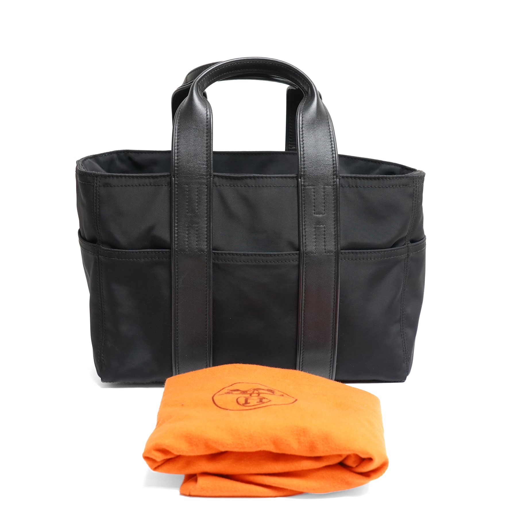 Hermès - Acapulco PM tote bag in black Toile Chevron canvas with black leather trim, the rectangular body with twin flat handles incorporating stitched H details, top zip fastening and eight exterior slip pockets, opening to a black nylon-lined interior with zip pocket, palladium-tone hardware, stamped Hermès Paris Made in France, with original Hermes dust bag