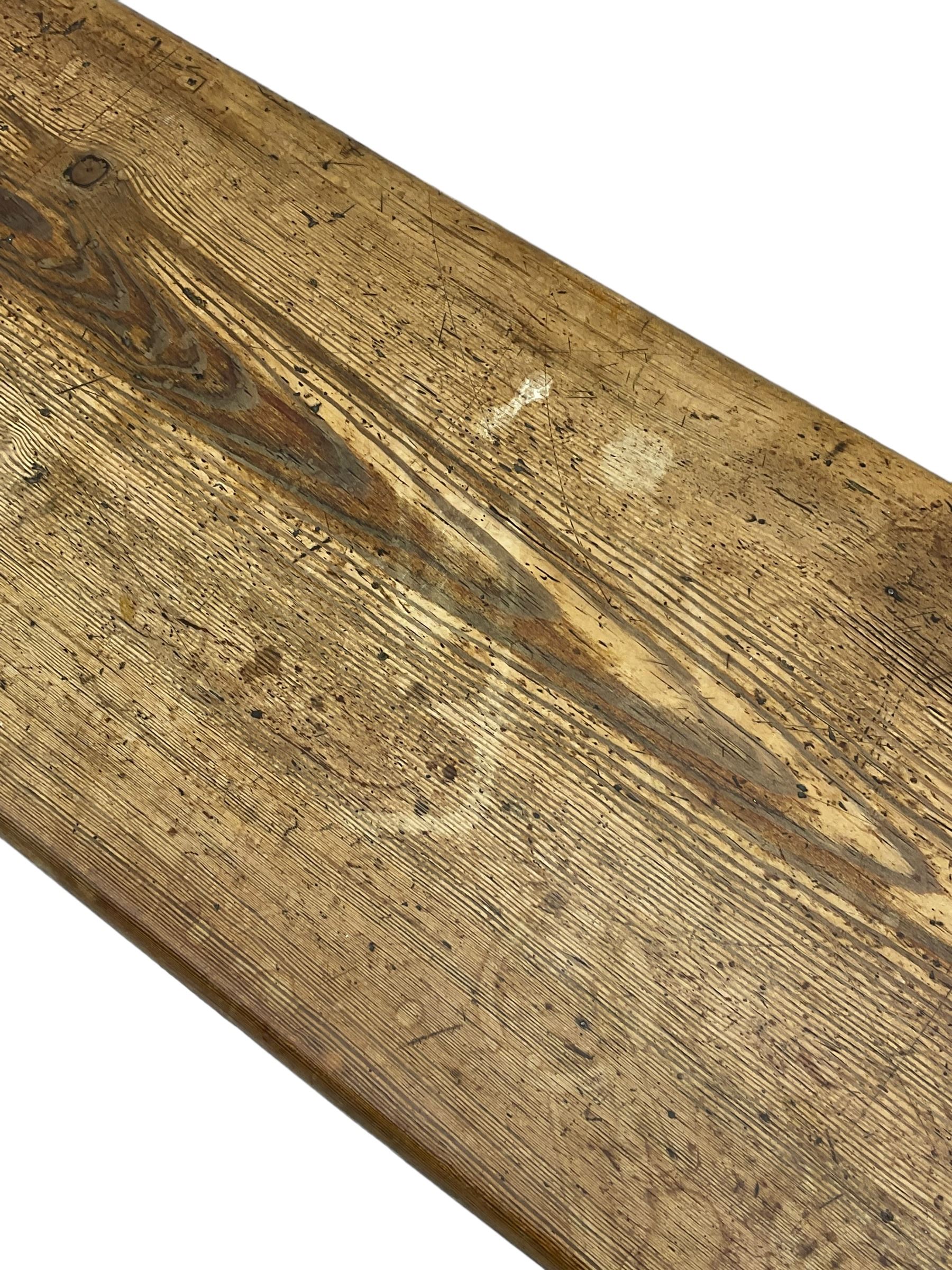 Late Victorian ecclesiastical pitch pine side table, rectangular bow-front top, on shaped end supports pierced with quatrefoils, united by pegged stretcher 