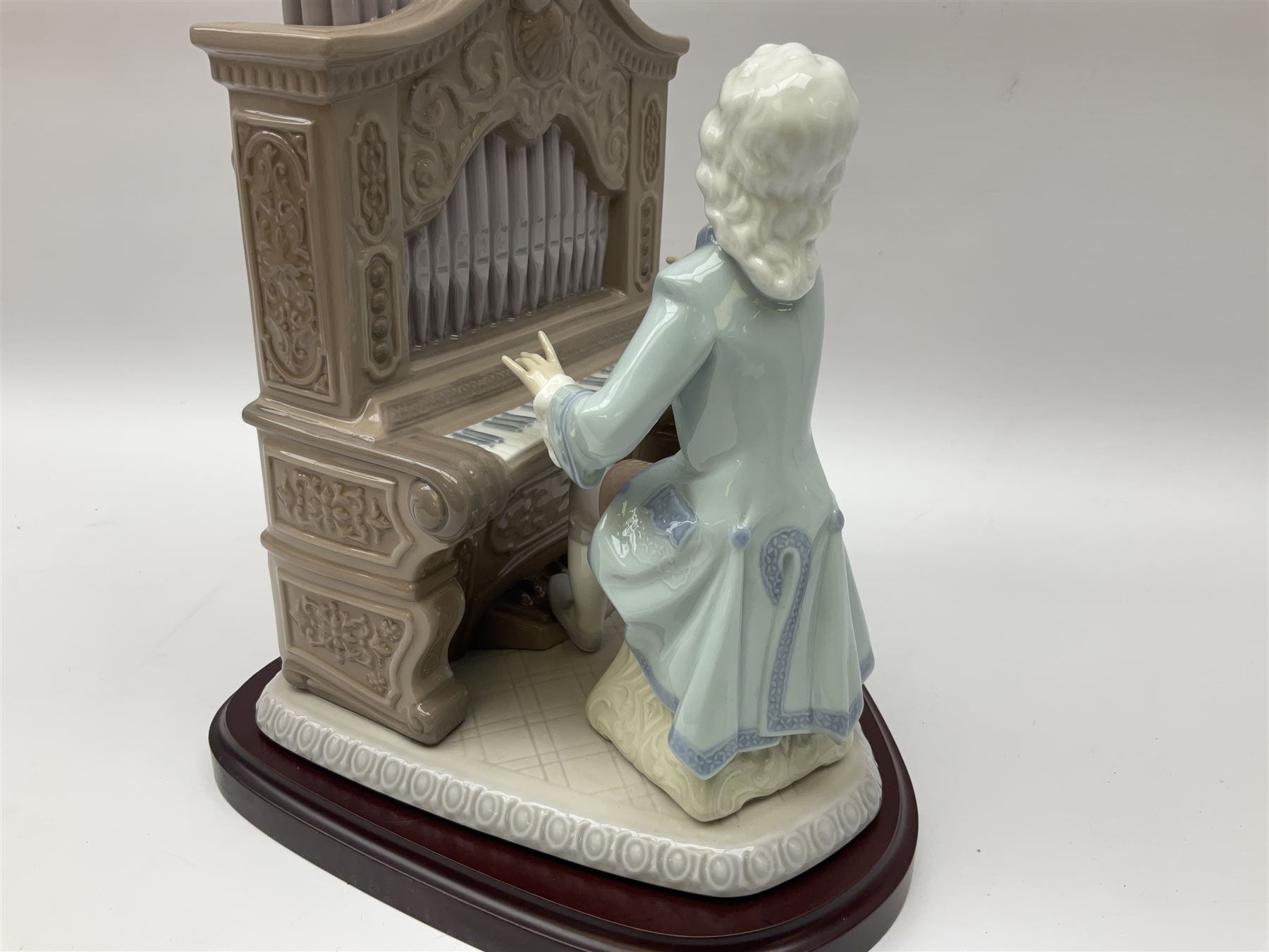 Lladro figure, Young Bach, modelled as a young Johann Sebastian Bach playing the piano, on a mahogany oval base, limited edition 2348/2500, in original box, no 1801, year issued 1994, year retired 1995, H29cm