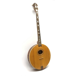Four-string banjo guitar with mahogany circular back and sides and spruce top, mother-of-pearl inlaid fingerboard and headstock, bears humorous label 'Fender Bedpanjo', L95cm