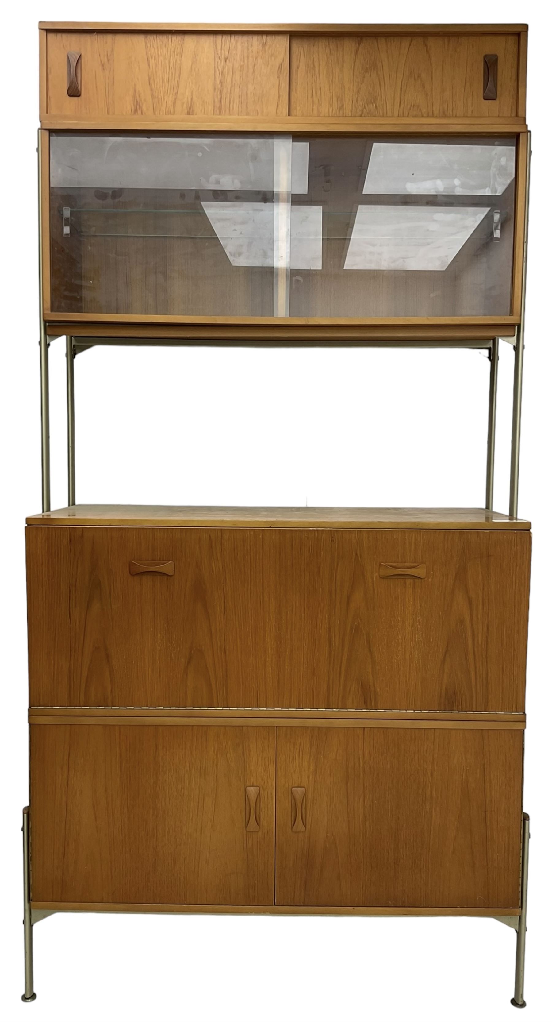 Remploy - mid-20th century teak sectional wall display unit or room divider, raised display cabinet section with sliding glass doors, central fall front section, lower double cupboard section and an additional sliding door section 