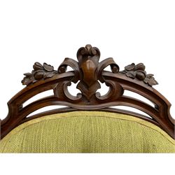 Victorian walnut settee, triple back with pierced and scroll-carved cresting rails over carved fruit and foliage decoration, upholstered in buttoned green fabric, serpentine seat and carved apron, on cabriole feet