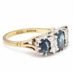 18ct gold sapphire and diamond ring, three graduating oval cut sapphires, the principal stone with two round brilliant cut diamonds set either side, London 1975, total sapphire weight approx 2.70 carat