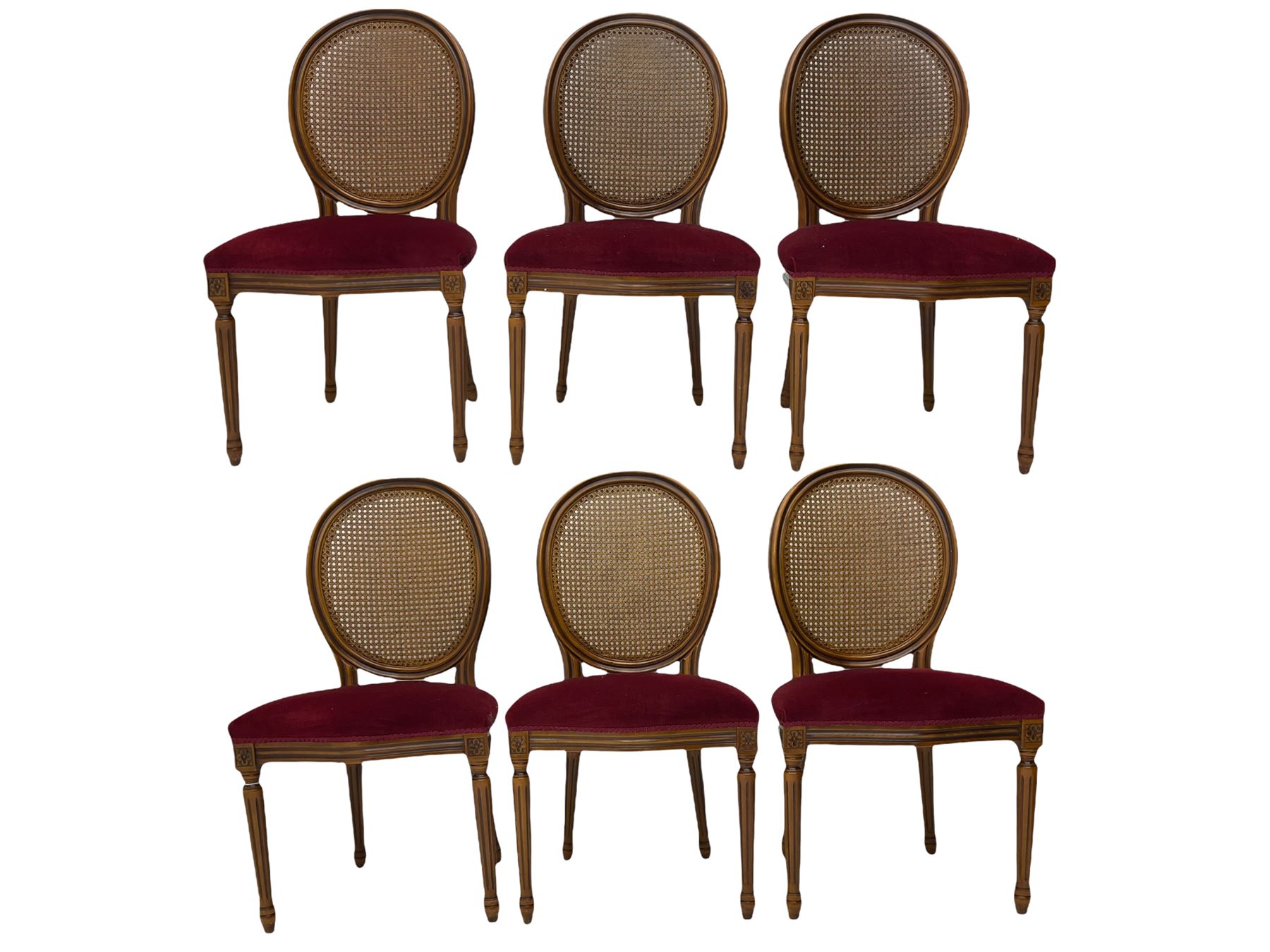 Set six French style walnut finish dining chairs, oval cane bergere backs over serpentine seats upholstered in red, flower head carved fluted supports