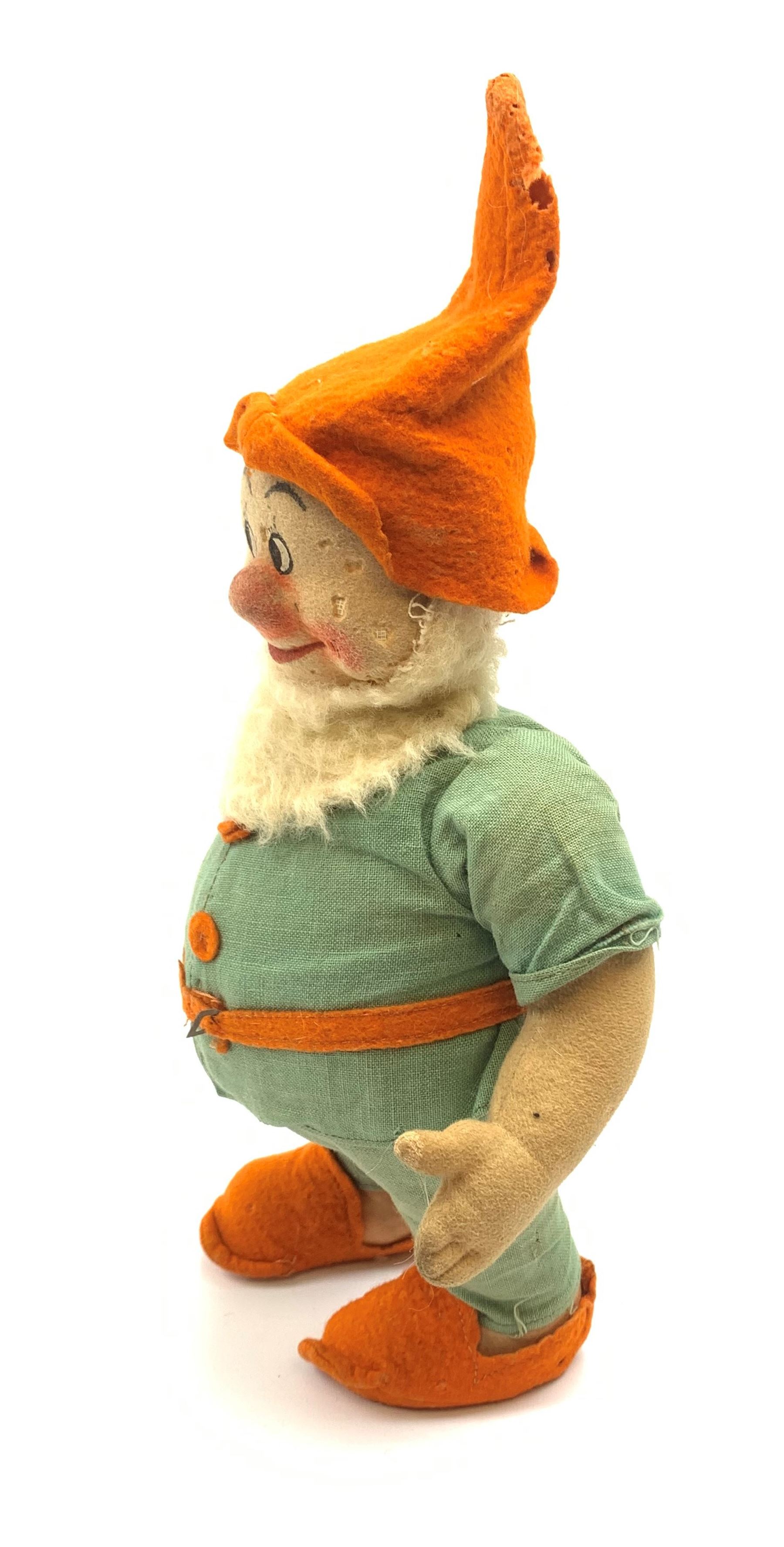 Chad Valley pressed felt figure of the Disney Snow White dwarf 'Doc' with painted facial features, standing wearing a green linen suit with orange hat, belt, buttons and shoes H13