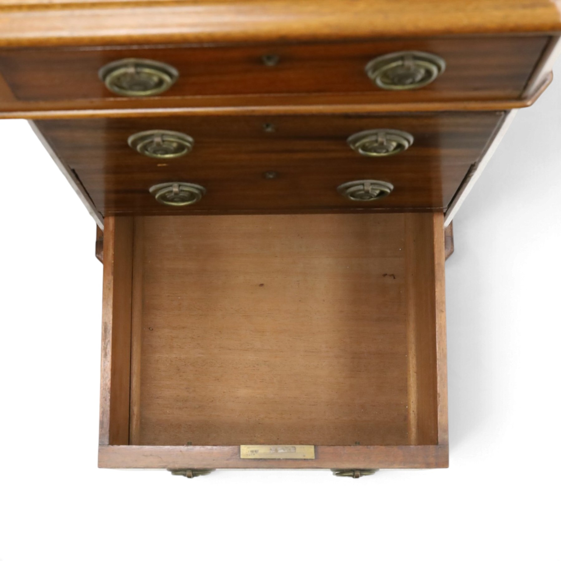 Late Victorian mahogany desk with red leather top, rectangular top with inset toold red leather writing surface, central long frieze drawer flanked by two short drawers, above pedestal with three graduating drawers with ring pull handles, on moulded plinth bases raised on castors