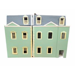 Two modern three storey dolls houses, each painted green with decorated interiors, both upon a single white wooden base, together with a large collection of dolls house furniture, accessories and figures 