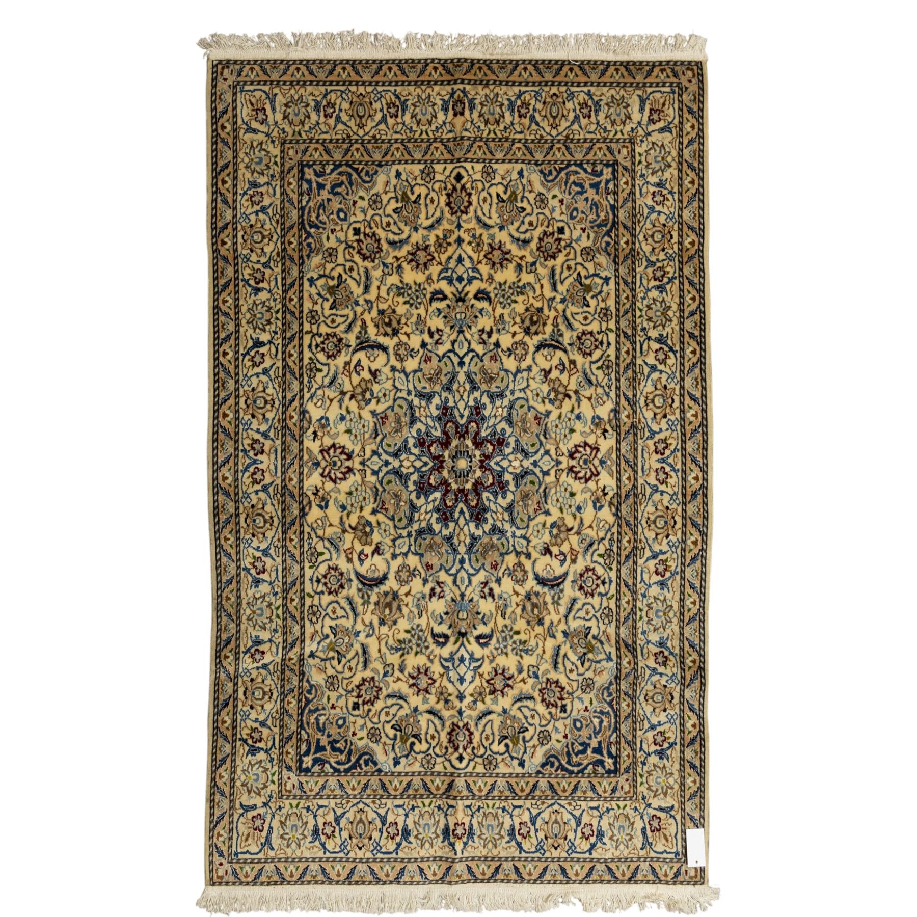 Central Persian fine Nain hand-knotted rug, ivory ground, with a central shaped floral medallion with pendants, surrounded by scrolling foliate and floral motifs incorporating rosettes, palmettes and delicate vine work in blue, cream and beige tones, enclosed by blue spandrels and an ivory border with repeating palmettes and meandering vines, flanked by floral guard stripes, with cotton fringes