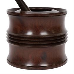 18th century lignum vitae captive mortar and pestle, the mortar of turned waisted form with central reeded girdle, and captive opening with rolled rim, H12.5cm D14cm, and pestle L17.5cm