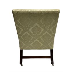 George III mahogany Gainsborough armchair, wide-seat and back upholstered in pale green damask fabric, the curved arm supports with turned roundels to terminals, raked back with out splayed supports and square front supports joined by plain stretcher rails, on brass castors