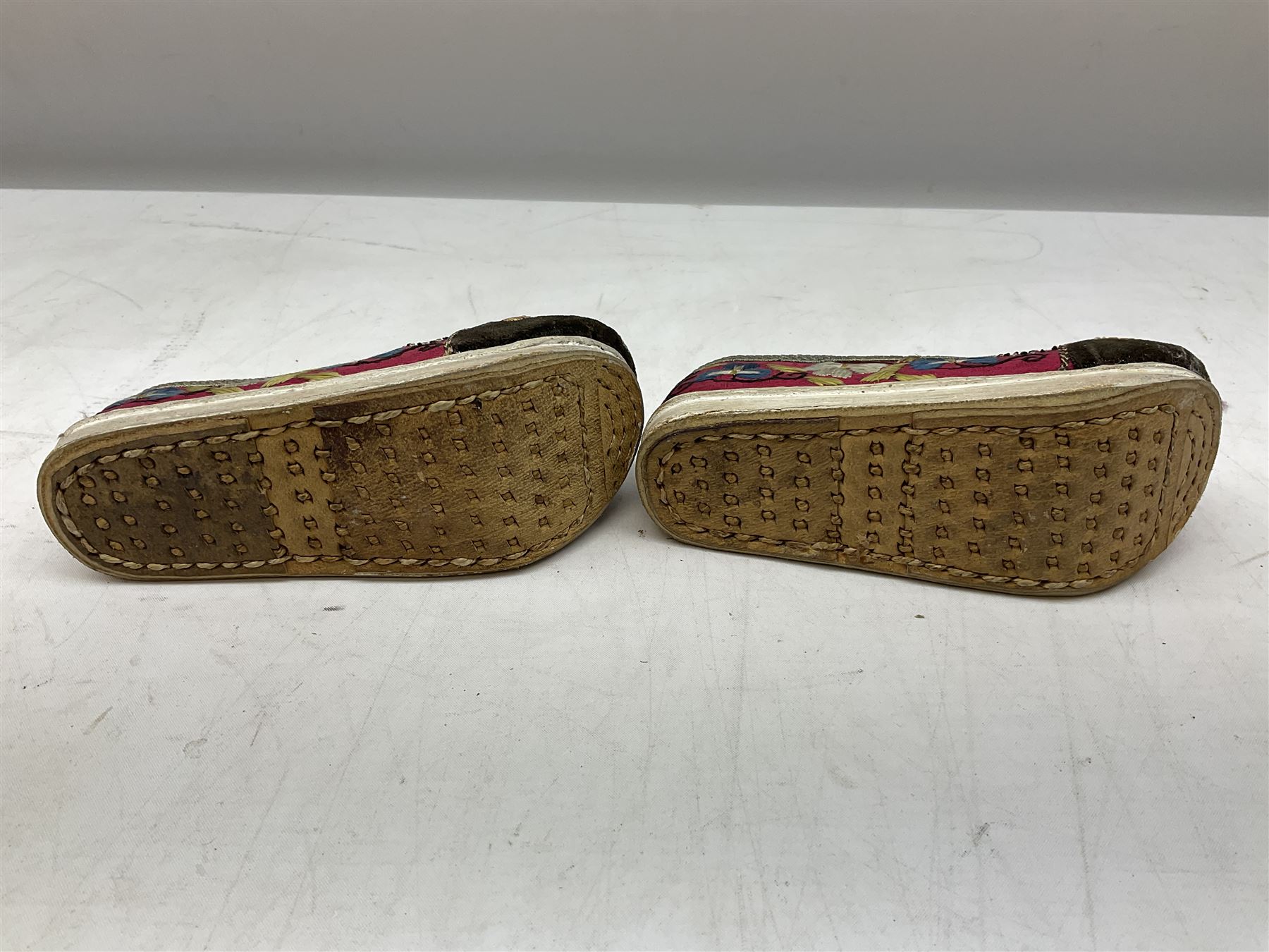 French silver plated wine taster of typical form, stamped, together with a silver plated napkin ring, and an 'Alpaca Silver' pill box with mother of pearl detailed cover, (3) together with Two pairs of late 19th/early 20th century Chinese Lotus shoes for binding feet, the first with purple silk heavily embroidered with ornate floral motifs, L10cm the second larger fuschia and black pair with thicker sole embroidered with flowers, L14cm