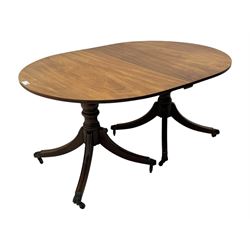 Georgian design mahogany twin pedestal dining table, oval top with reeded edge, single additional leaf, on turned pedestal with four out splayed supports, cast brass hairy paw castors 
