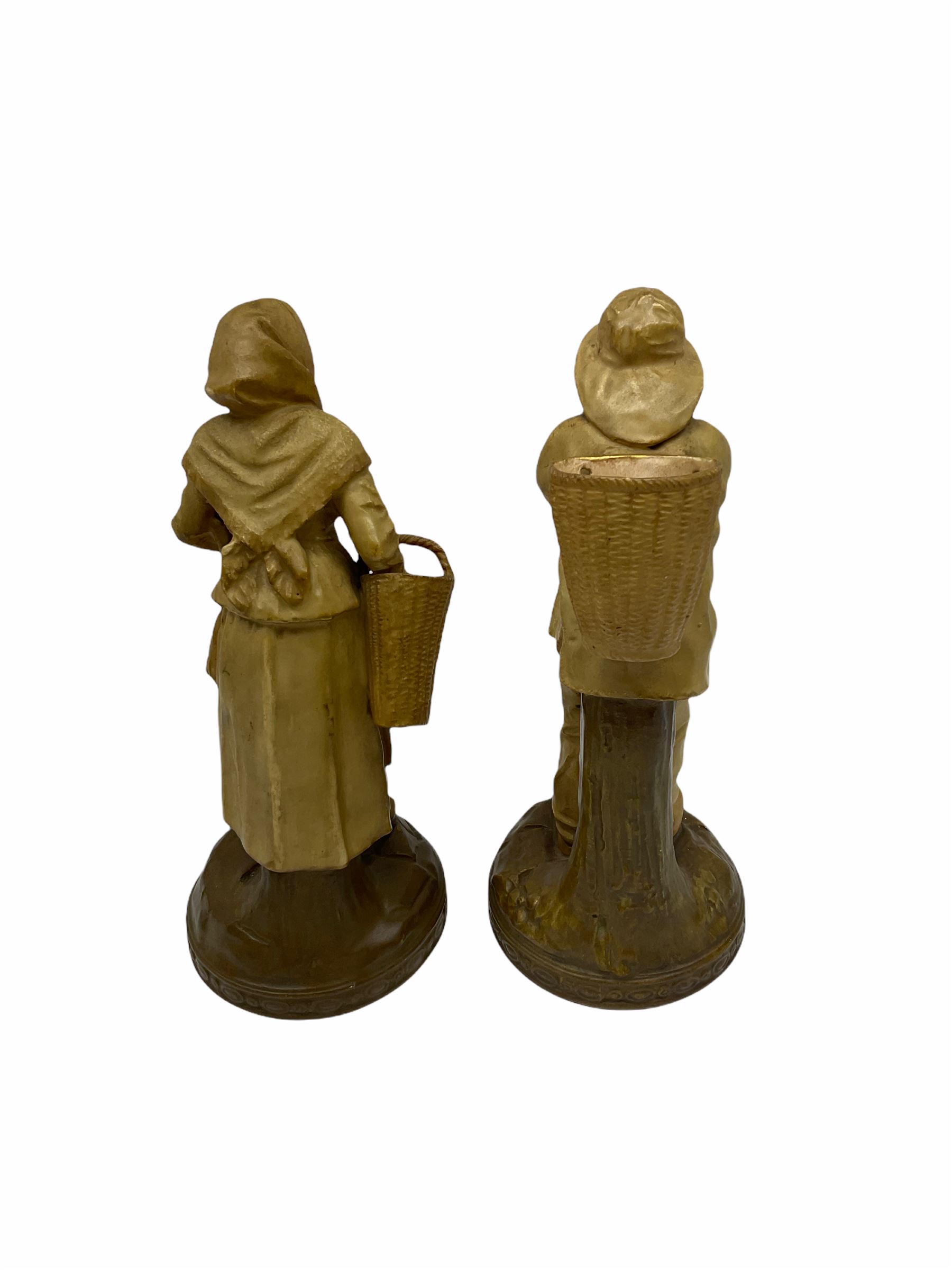 Royal Dux figure modelled as a fish seller, with applied triangle mark to the base and impressed model number 2292, H27cm, together with three Royal Dux style elephants, and a pair of Austrian Turn Wien figures, each carrying 'striker' baskets for matches. 