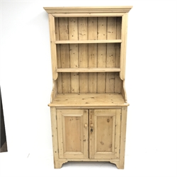 Mid century narrow pine dresser, projecting cornice, two tier plate rack above two cupboards, shaped solid end supports, W92cm, H189cm, D43cm