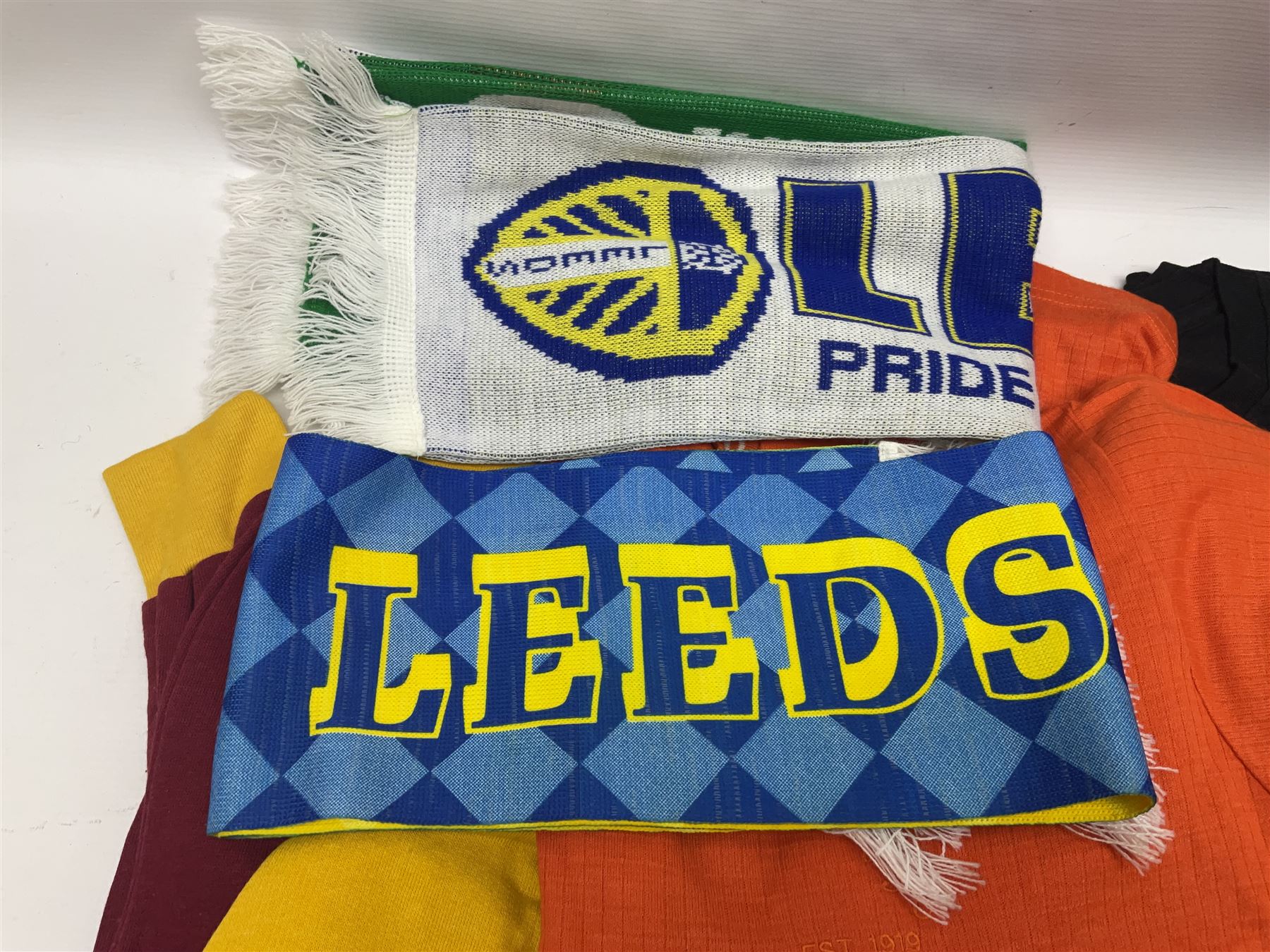 Collection of Leeds United scarves, hats and t-shirts, together with a Washington Redskins NFL sweatshirt and an Australian rugby league shirt