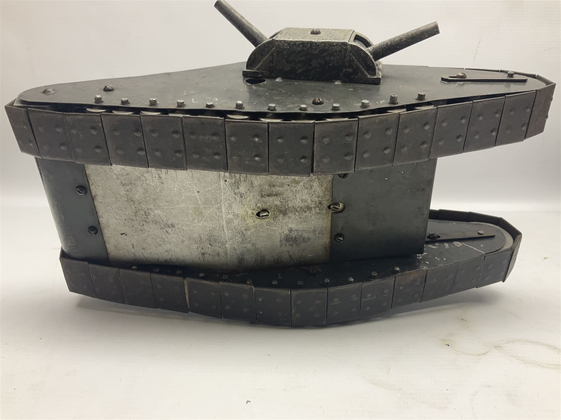 Large clockwork model of a WW1 Tank made of tin-plate and aluminium, with moving side cannons, the clockwork chain driven movement driving the articulated tin tracks; L28.5cms  W16.5cms and H13.5cms