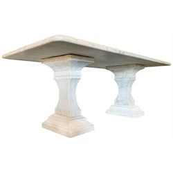 Classical Grecian design Carrera marble centre table, the rectangular single slab top with rounded corners and carved edge, raised on twin pedestals comprised of three pieces with a waisted column on a stepped plinth