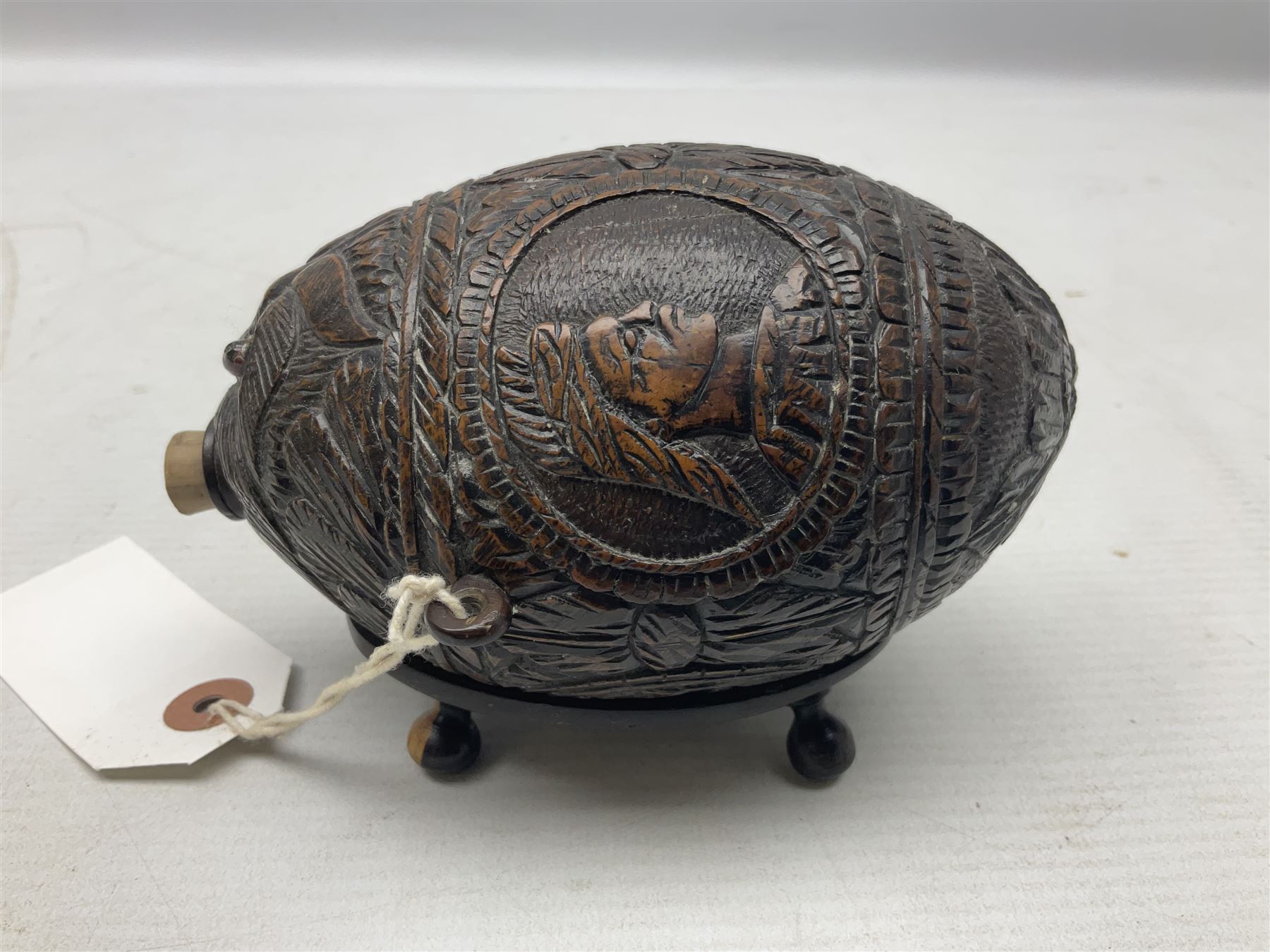 19th century bug bear flask carved with Balkan figures, a wolf and leafage with glass eyes, L14cm on stand 