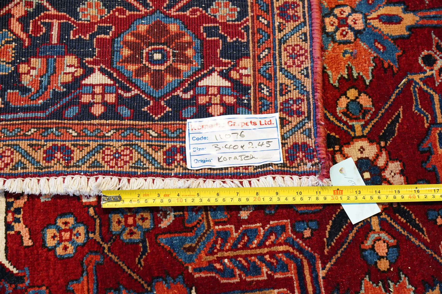 North West Persian Karadja hand-knotted carpet, deep red field decorated with an all-over lattice design of elongated geometric devices interspersed with rosettes and angular palmettes, enclosed by a dark indigo main border of stylized floral and geometric motifs between multiple guard stripes, with cotton fringe ends 