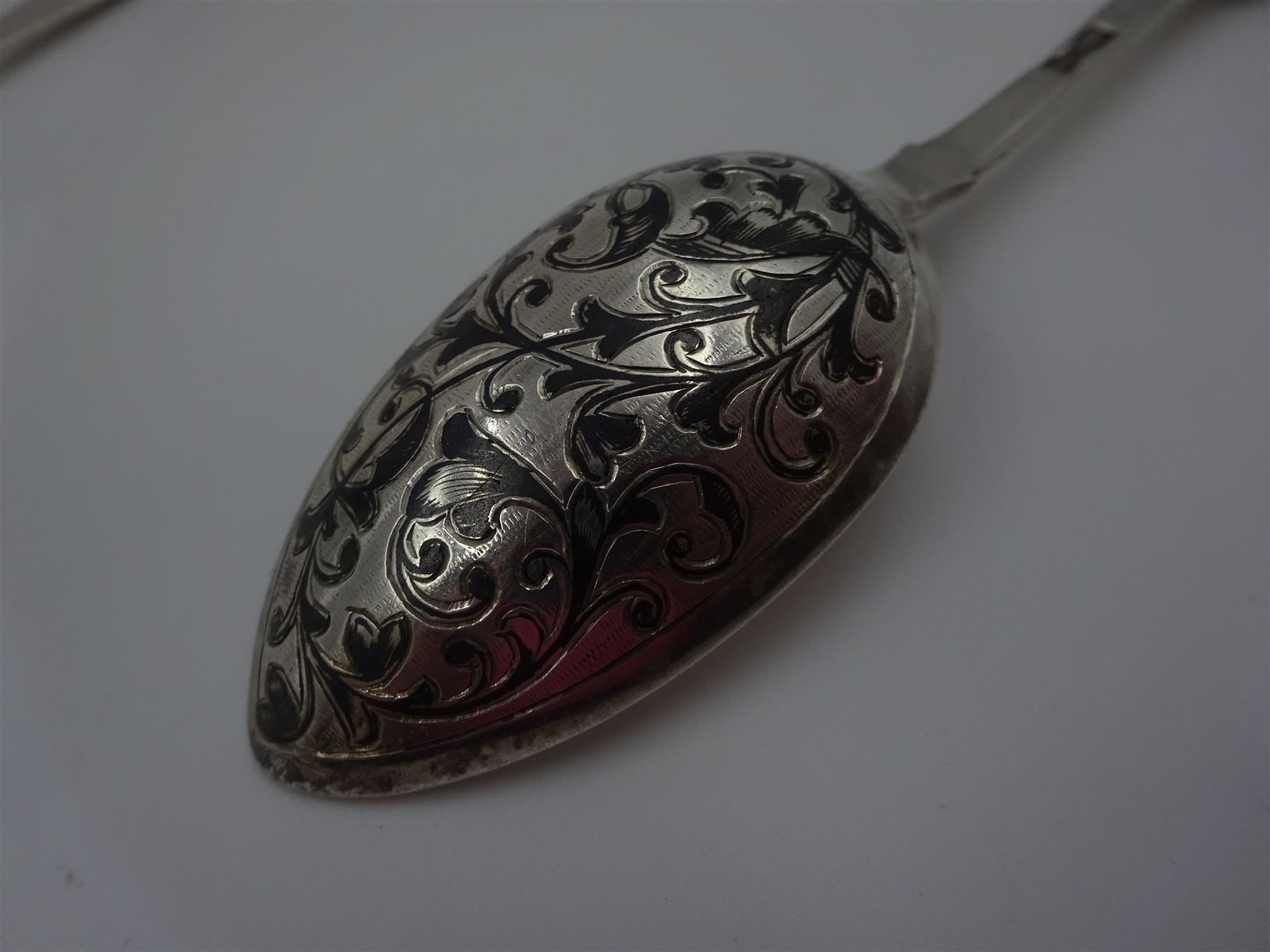 Late 19th century Russian silver Fiddle pattern niello work spoon, marked for 84 standard, Moscow, assayer Aleksander Vladislavovich Skovronsky, maker possibly Ivan Kuzmich Yashin, together with a Russian silver cake slice, marked with Kokoshnik mark, 84 standard, St Petersburg, maker Petr Chuksanov, and a pair of early 20th century silver sugar tongs, with shell bowls, hallmarked James Dixon & Sons Ltd, Sheffield 1913