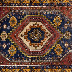 Turkish Anatolian wool rug, central stepped medallion on dark blue lozenge field, red spandrels with stylised hooked motifs, ochre border decorated with repeating geometric motifs and guard stripes