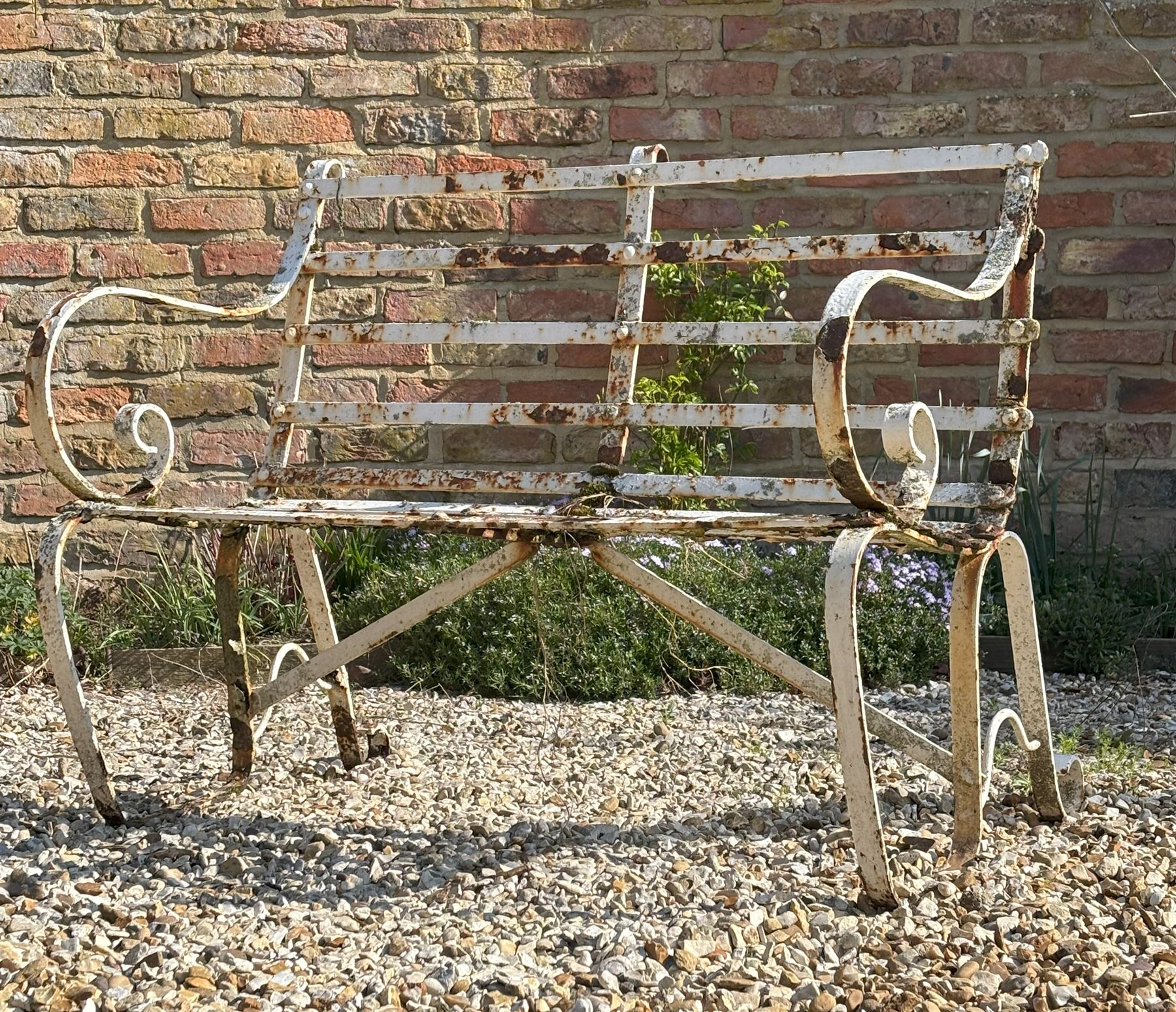 19th century riveted strapwork iron two seat garden bench with scrolled arms and supports. H83cm, L101cm, D70cm.  - COLLECTION BY APPOINTMENT FROM: The White House, Thirsk Road, Easingwold, York, YO61 3NF - CALL 01723 507111 TO ARRANGE