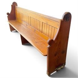 Early 20th century stained pine ecclesiastical church pew, the shaped end supports flanking slatted and panelled back, with black stencilled number '15' to the side