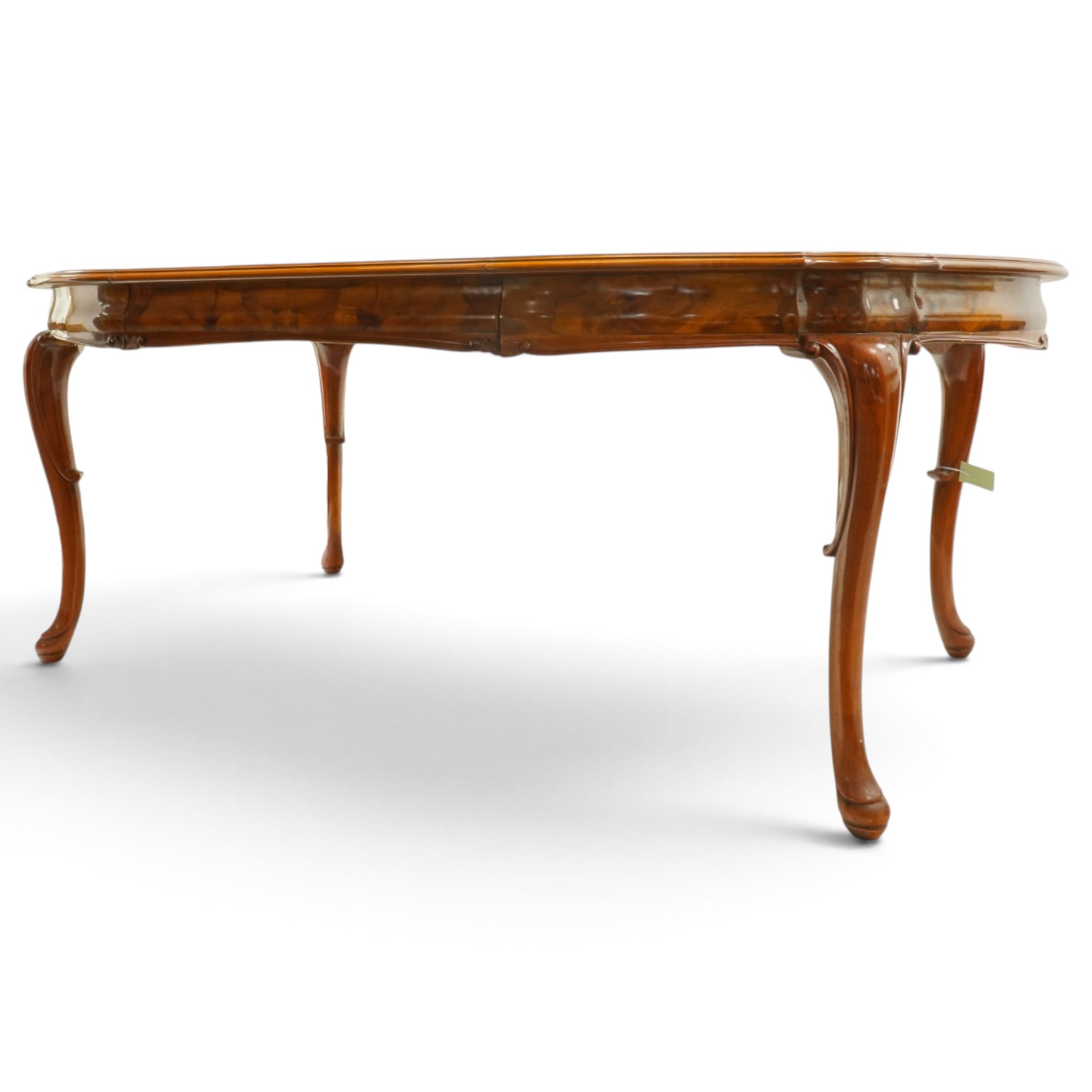 Dutch design figured walnut extending dining table, the shaped circular extending top with book-matched veneer and moulded edge, shaped banded frieze over scroll-moulded lower rail, raised on C-scroll carved cabriole supports with pad feet, with additional leaf