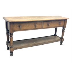 Late 19th century oak potboard dresser base, rectangular top over two frieze drawers with turned wooden handles, raised on four ring turned and tapering supports with block feet, united by a full-width lower potboard