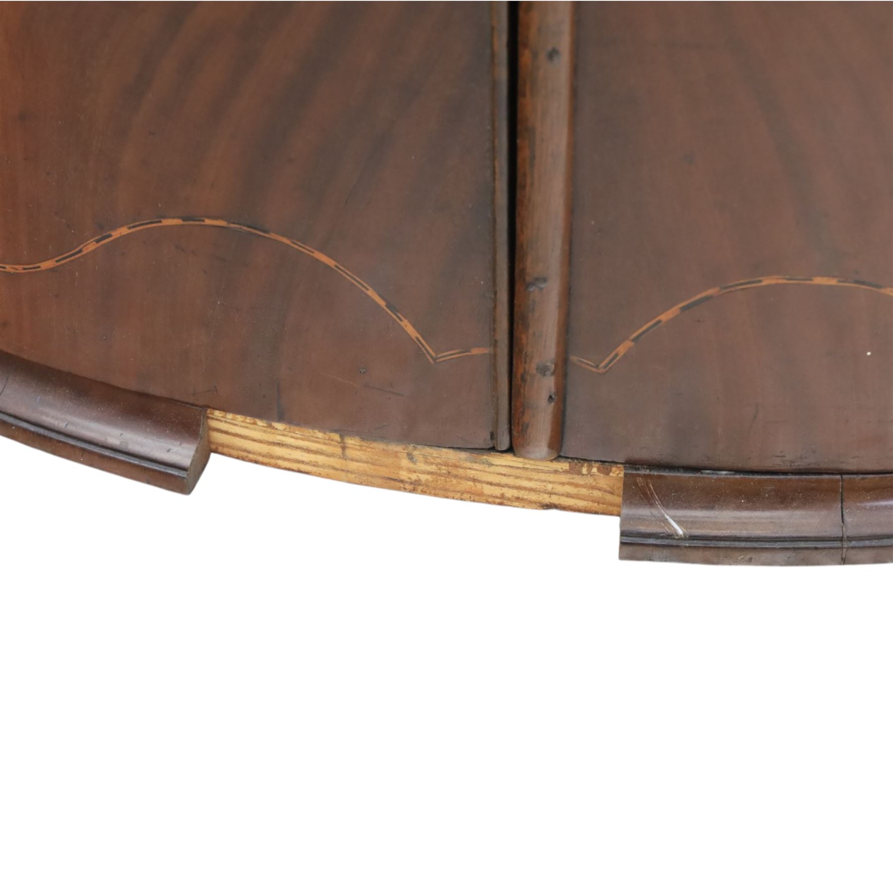 George III mahogany bow-front corner cupboard, projecting moulded cornice over satinwood inlaid frieze with geometric crossbanding, enclosed by twin shaped panel doors with line inlay and ornate brass escutcheon plates, painted interior fitted with shaped shelves, on moulded plinth base