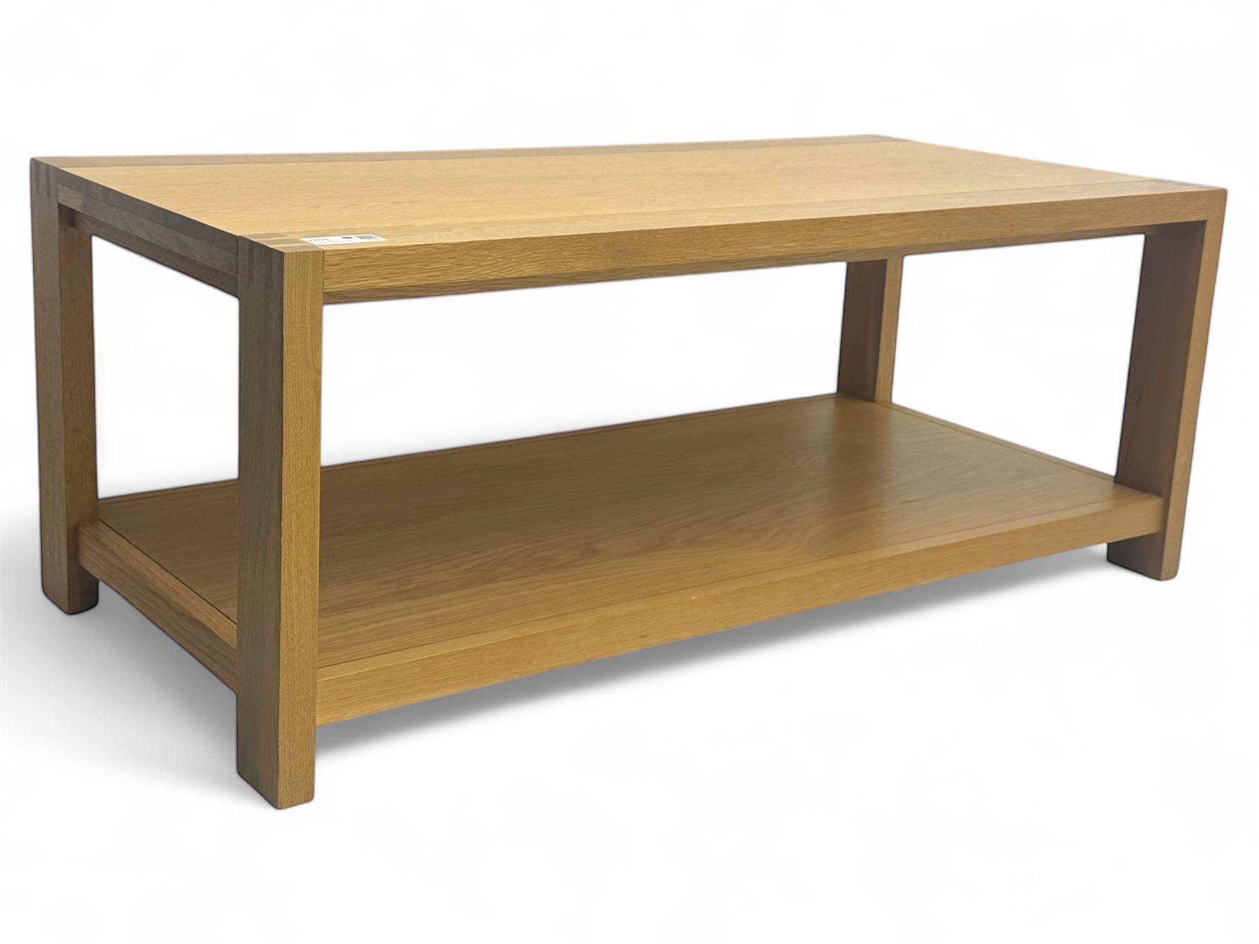 Light oak rectangular coffee table, with exposed finger joints to the corners, raised above a full-length undertier on straight supports