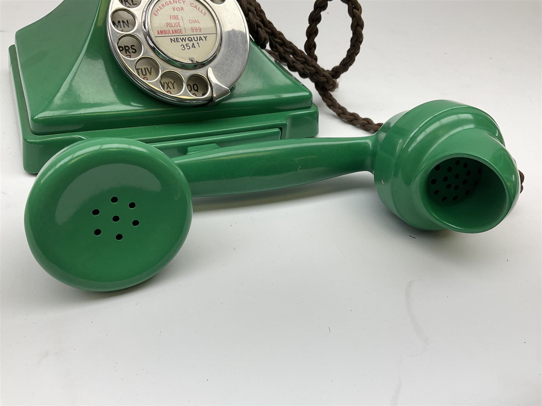 Jade green Bakelite telephone, of pyramid form with rotary alphabet dial, brown braided handset cord and a base draw, W18cm D14cm H15cm