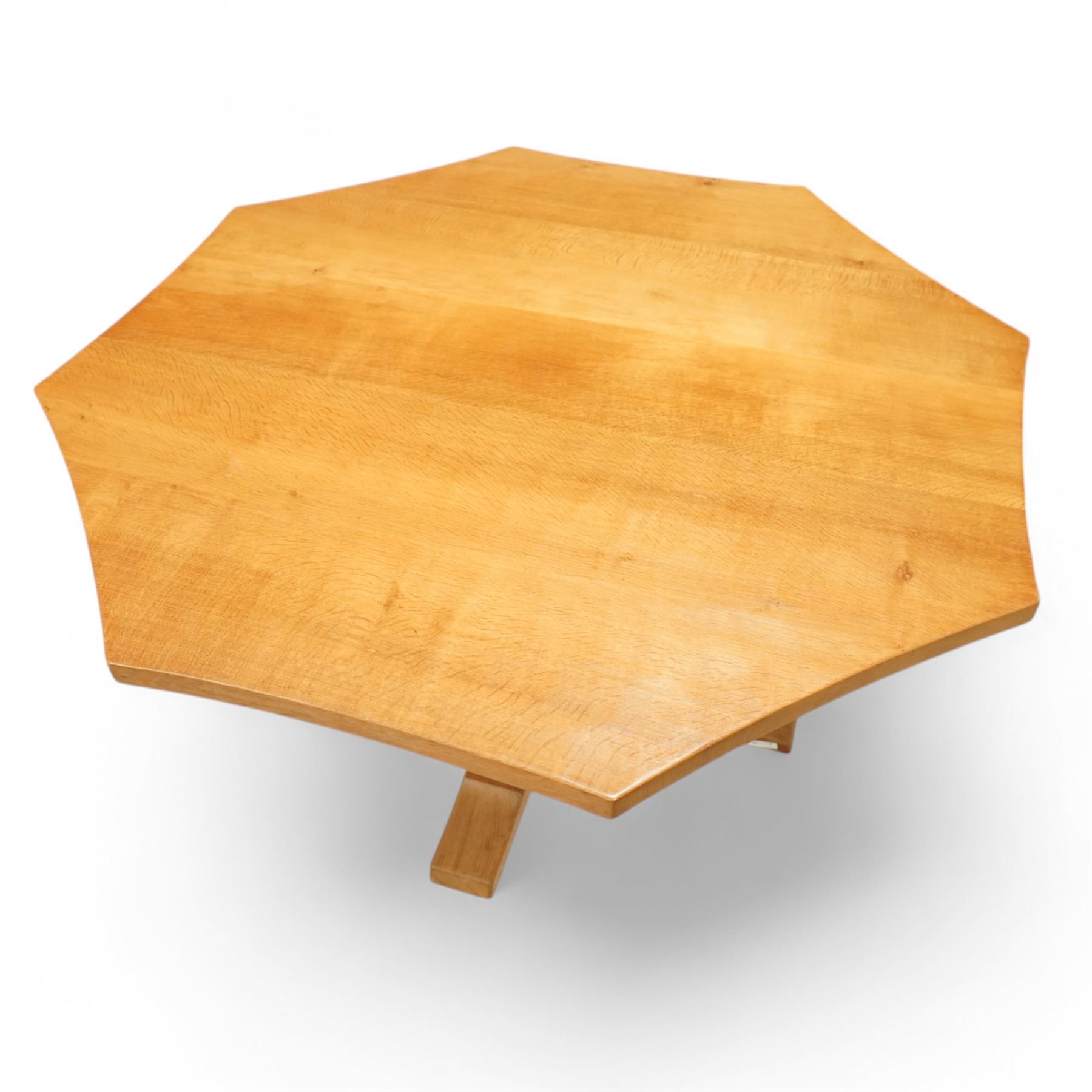 Mouseman - adzed oak octagonal concave dining table, raised on cruciform base, the supports and sledge feet also adzed, carved with fat mouse signature, by the workshop of Robert Thompson, Kilburn