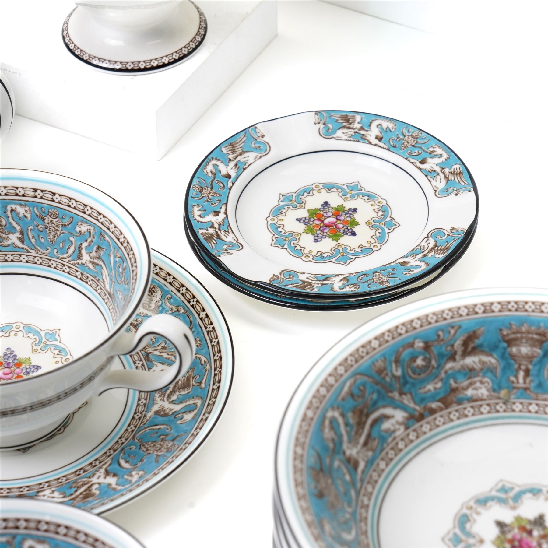 Wedgwood turquoise Florentine part service, comprising large covered tureen and stand, coffee pot, teapot, two covered sucriers, milk jug, two sauce boats and stands, seven soup plates, three bowls, jug, eighteen soup bowls and fifteen stands, two ashtrays, thirteen further saucers, twelve teacups and eleven saucers, and twenty-one further plates of varying sizes