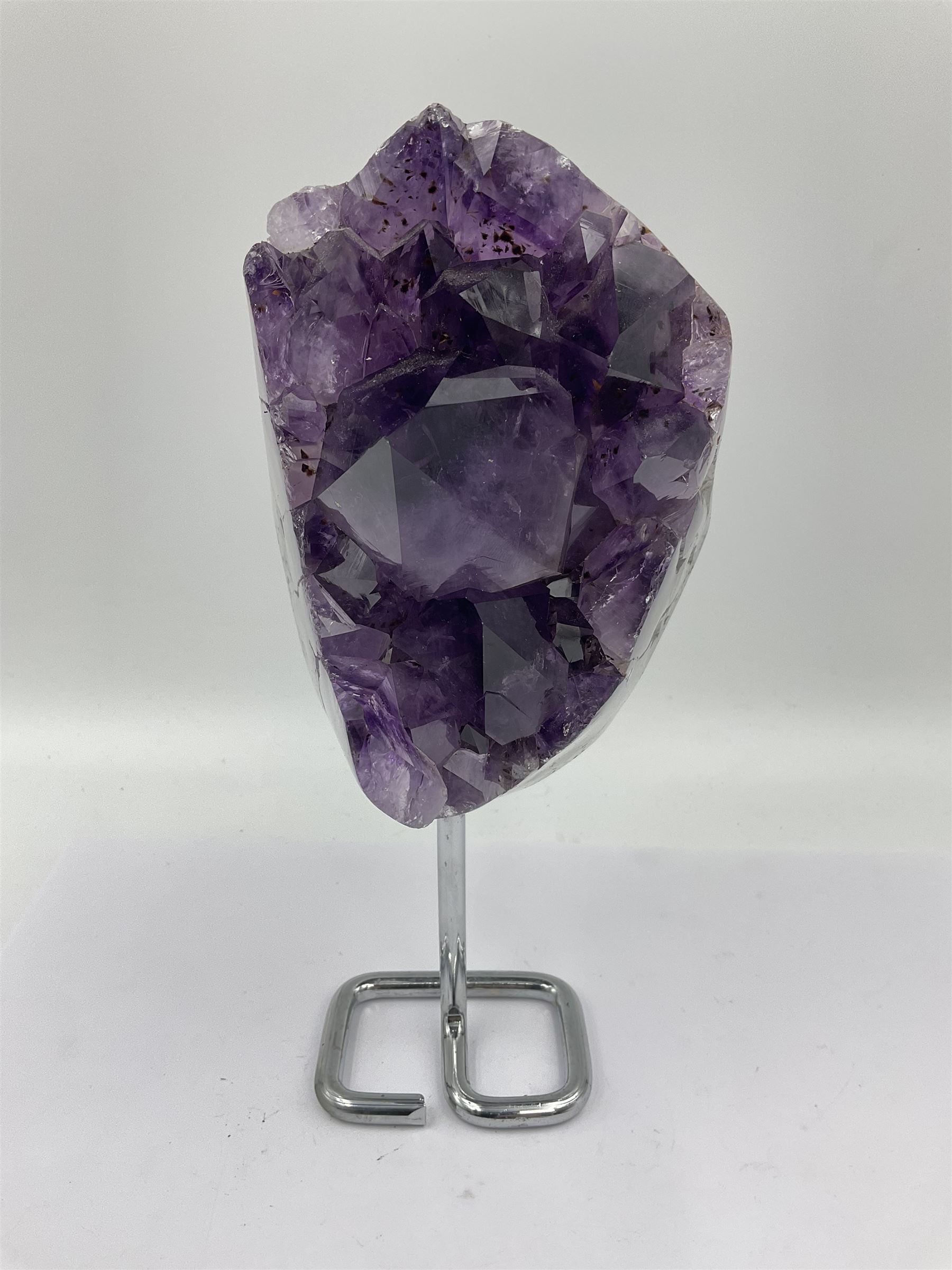 Amethyst crystal geode cluster, with large well-defined crystals, upon a metal stand, H21cm